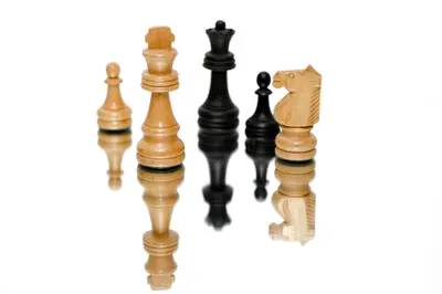 Wooden chess pieces standing on a white background