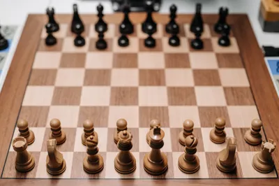 A wooden chess board set up at the start of a game